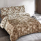 Brown and beige floral patterned comforter set on a bed in a bedroom.