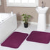 Two rectangular purple door mats with a diamond pattern, placed on a bathroom floor near the entrance.