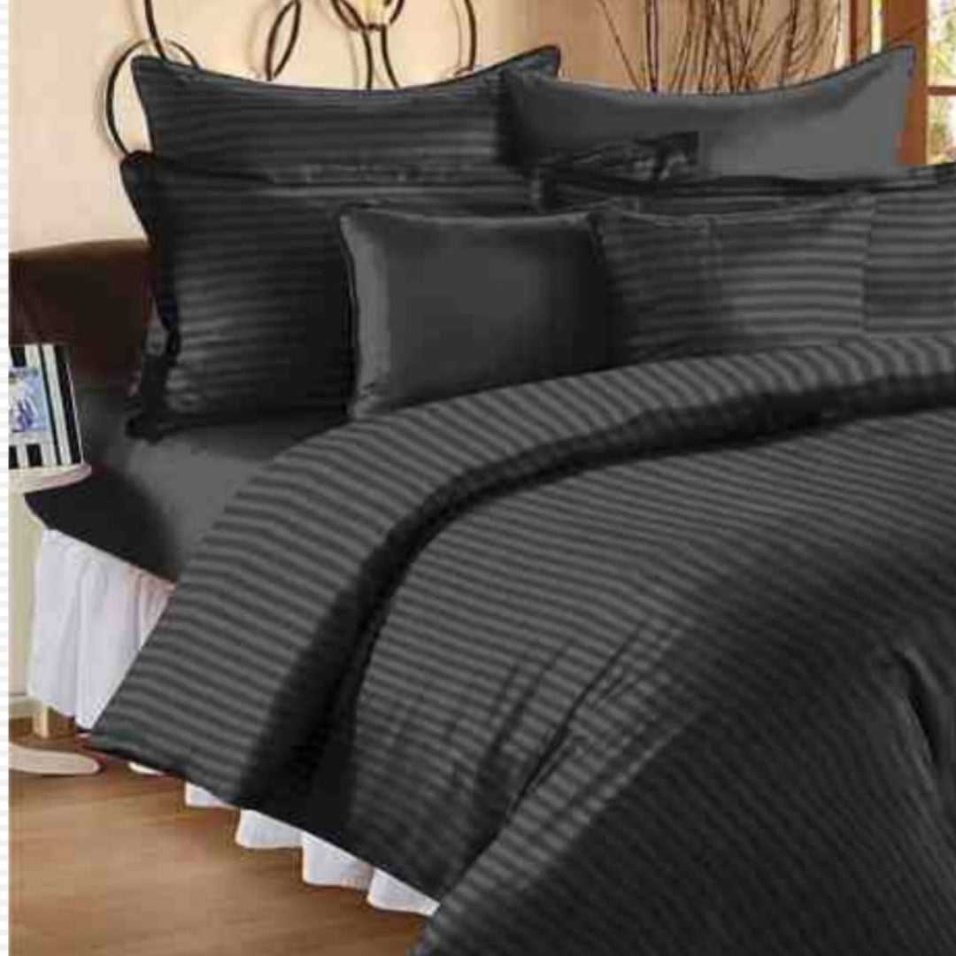 A set of black colored king-size bed sheets with plum stripes, displayed on a bed with pillow covers.
