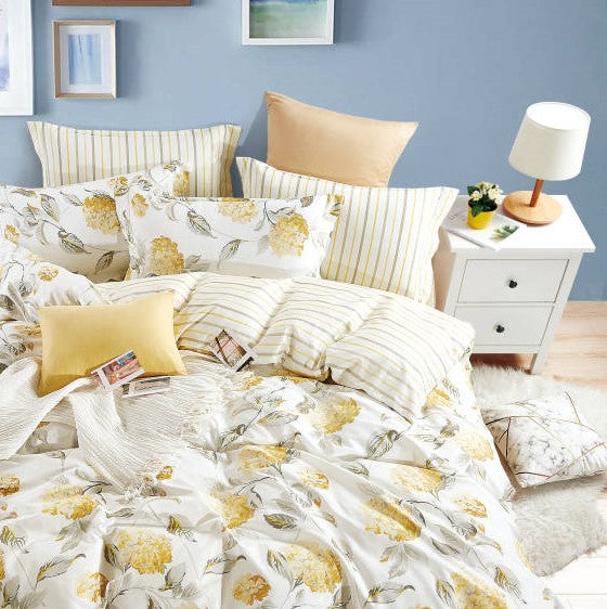 A king size bed sheet set with floral and striped patterns, including two pillow covers, displayed on a bed in a bedroom setting.